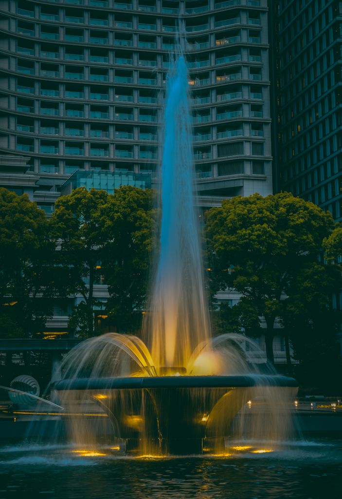 Captivating shot of Wadakura Fountain at evening with city buildings in the background, Tokyo, Japan.